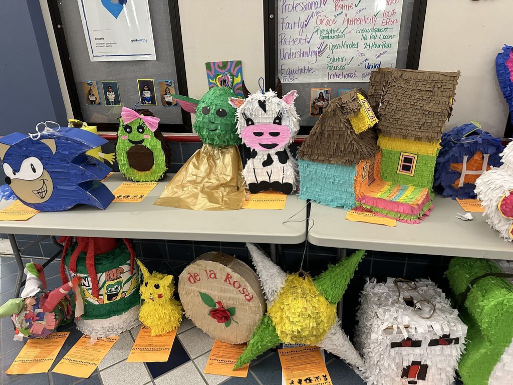 Student created pinatas on a table and floor